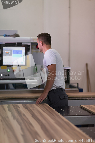 Image of worker in a factory of wooden furniture
