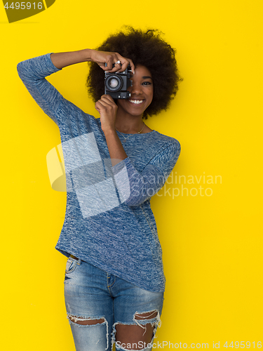 Image of young african american girl taking photo on a retro camera