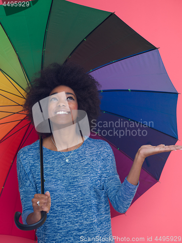 Image of afro american woman holding a colorful umbrella