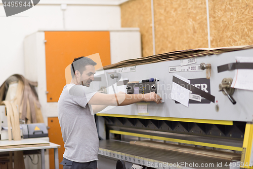 Image of worker in a factory of wooden furniture