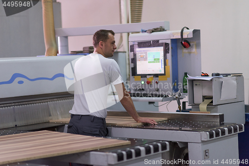 Image of worker in a factory of wooden furniture