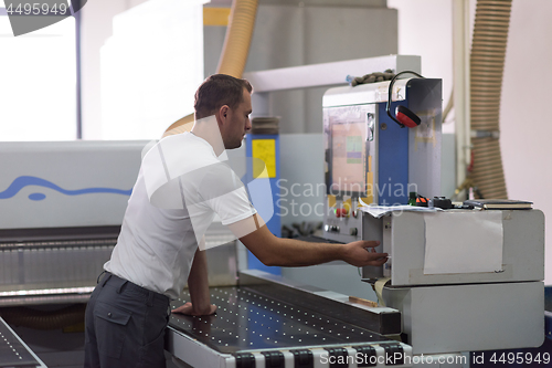 Image of worker in a factory of wooden furniture