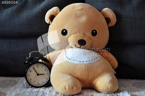 Image of Cute teddy bear hold alarm clock