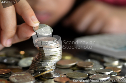 Image of Coin piles and hand holding coin