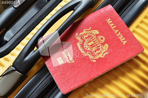 Image of Malaysia passport on a yellow suitcase