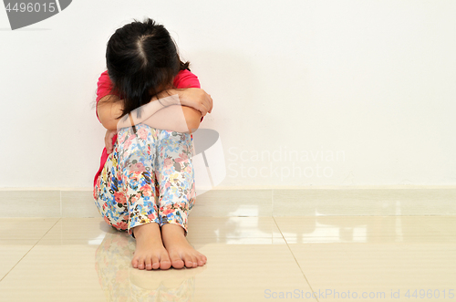 Image of Sad little girl sit on the floor.