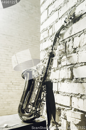 Image of Saxophone On The Brick Wall Background - Vintage Toned Image