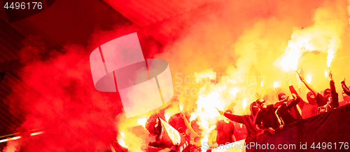 Image of football hooligans with mask holding torches in fire