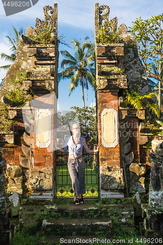 Image of Young blonde caucasian woman traveling and exploring traditional hidu tamples around Ubud on Bali.