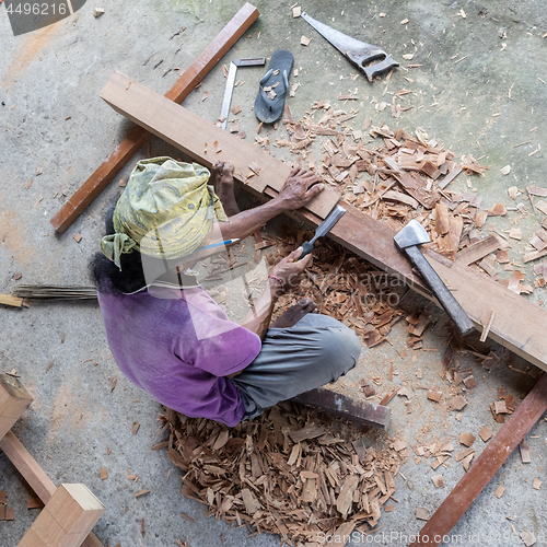 Image of Carpenter working in traditional manual carpentry shop in a third world country.