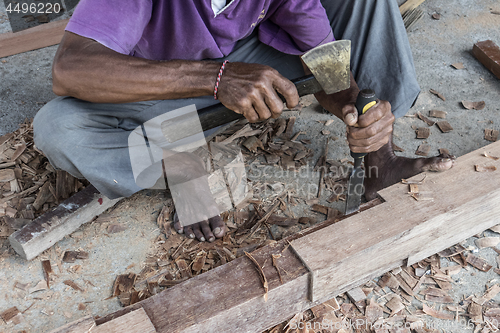 Image of Close up of warn hands of carpenter working in traditional manual carpentry shop in a third world country.