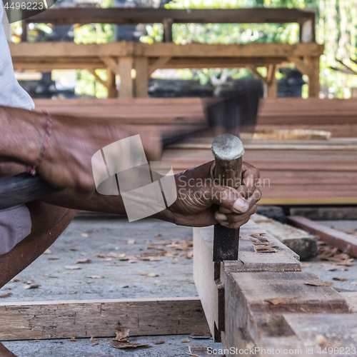 Image of Close up of warn hands of carpenter working in traditional manual carpentry shop in a third world country.