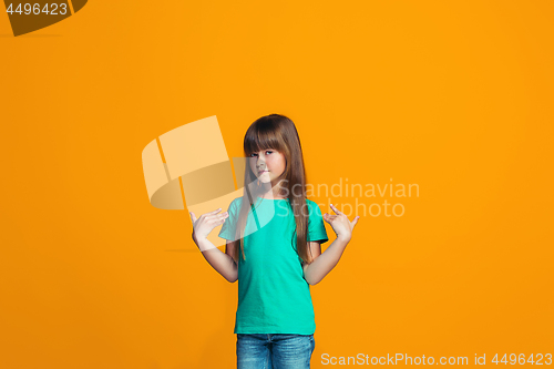 Image of The happy teen girl standing and smiling against pink background.