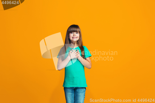 Image of Beautiful teen girl looking suprised isolated on orange