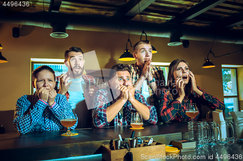 Image of Sport, people, leisure, friendship and entertainment concept - happy football fans or male friends drinking beer and celebrating victory at bar or pub