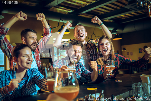 Image of Sport, people, leisure, friendship and entertainment concept - happy football fans or male friends drinking beer and celebrating victory at bar or pub