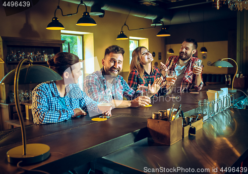 Image of Sport, people, leisure, friendship and entertainment concept - happy football fans or male friends drinking beer and celebrating victory at bar or pub