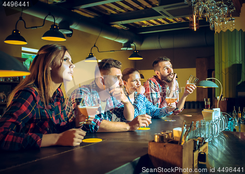 Image of Sport, people, leisure, friendship and entertainment concept - happy football fans or male friends drinking beer and celebrating victory at bar or pub