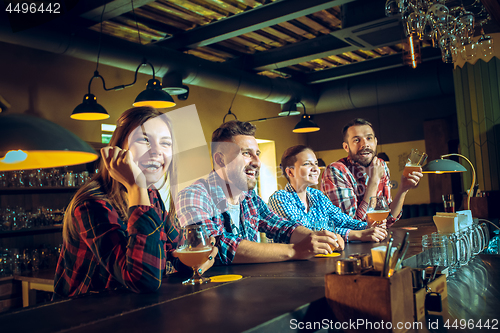 Image of Sport, people, leisure, friendship and entertainment concept - happy football fans or male friends drinking beer and celebrating victory at bar or pub