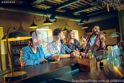 Image of Sport, people, leisure, friendship and entertainment concept - happy football fans or male friends drinking beer and celebrating victory at bar or pub