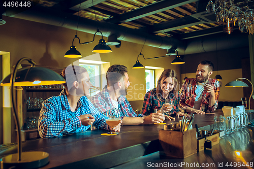 Image of Sport, people, leisure, friendship and entertainment concept - happy football fans or male friends drinking beer and celebrating victory at bar or pub