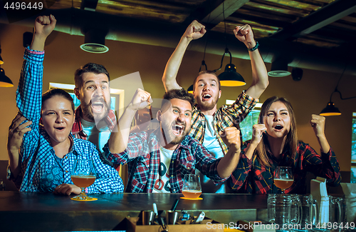 Image of Sport, people, leisure, friendship and entertainment concept - happy football fans or male friends drinking beer and celebrating victory at bar or pub