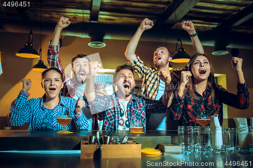 Image of Sport, people, leisure, friendship and entertainment concept - happy football fans or male friends drinking beer and celebrating victory at bar or pub