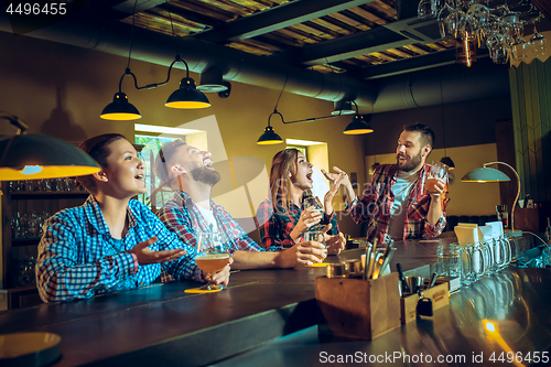 Image of Sport, people, leisure, friendship and entertainment concept - happy football fans or male friends drinking beer and celebrating victory at bar or pub