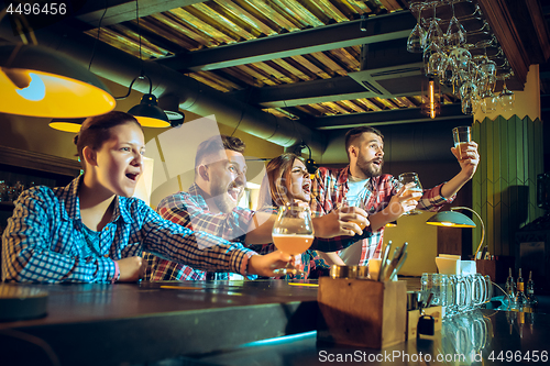 Image of Sport, people, leisure, friendship and entertainment concept - happy football fans or male friends drinking beer and celebrating victory at bar or pub