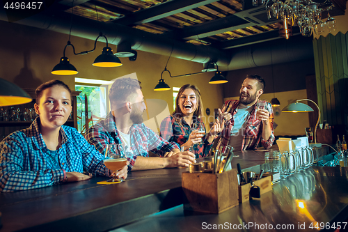 Image of Sport, people, leisure, friendship and entertainment concept - happy football fans or male friends drinking beer and celebrating victory at bar or pub