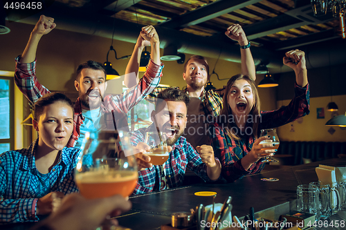 Image of Sport, people, leisure, friendship and entertainment concept - happy football fans or male friends drinking beer and celebrating victory at bar or pub