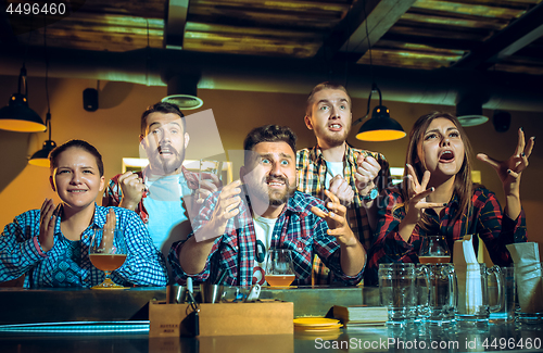 Image of Sport, people, leisure, friendship and entertainment concept - happy football fans or male friends drinking beer and celebrating victory at bar or pub