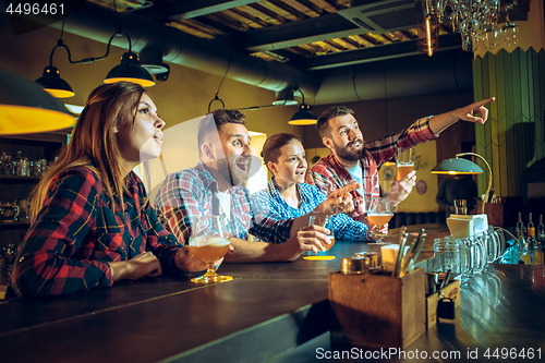 Image of Sport, people, leisure, friendship and entertainment concept - happy football fans or male friends drinking beer and celebrating victory at bar or pub