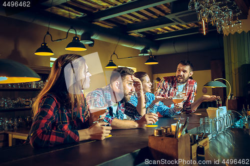 Image of Sport, people, leisure, friendship and entertainment concept - happy football fans or male friends drinking beer and celebrating victory at bar or pub