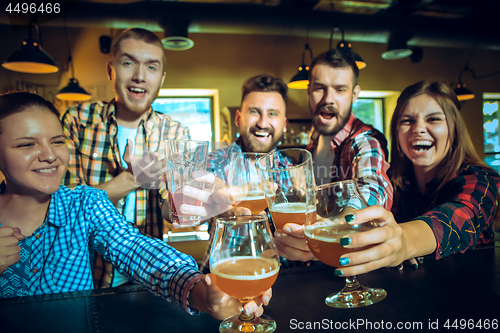 Image of Sport, people, leisure, friendship and entertainment concept - happy football fans or male friends drinking beer and celebrating victory at bar or pub