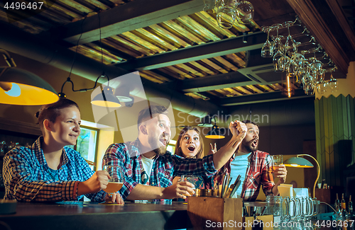 Image of Sport, people, leisure, friendship and entertainment concept - happy football fans or male friends drinking beer and celebrating victory at bar or pub