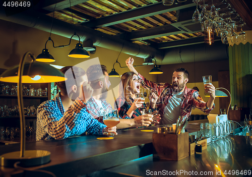 Image of Sport, people, leisure, friendship and entertainment concept - happy football fans or male friends drinking beer and celebrating victory at bar or pub