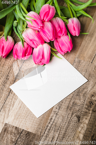 Image of Beautiful bouquet of pink tulips and congratulations on the tabl