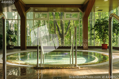 Image of Big round jacuzzi bath in spa center, early morning