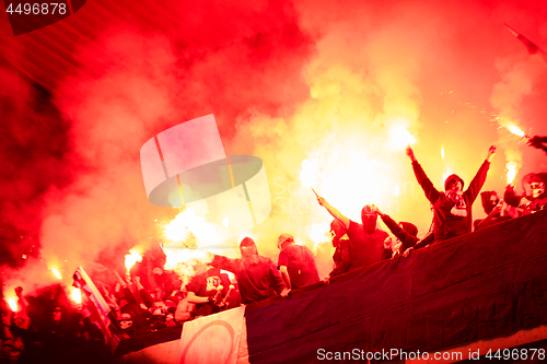 Image of football hooligans with mask holding torches in fire