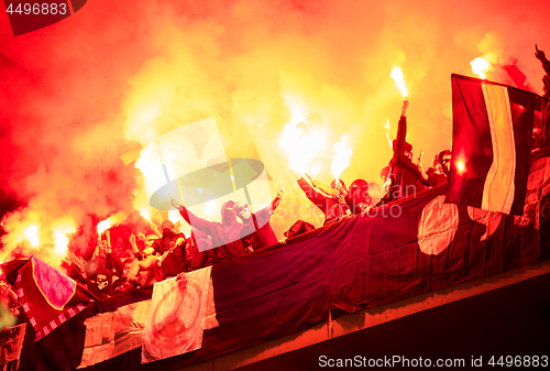 Image of football hooligans with mask holding torches in fire