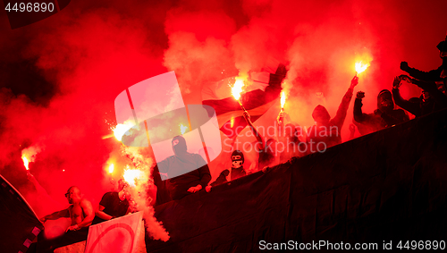 Image of football hooligans with mask holding torches in fire