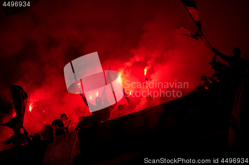 Image of football hooligans with mask holding torches in fire