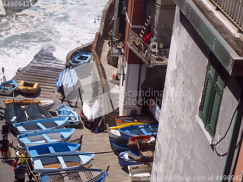 Image of editorial boats on pavement waterfront Riomaggiore, Cinque Terre