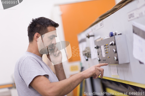 Image of engineer in front of wood cutting machine
