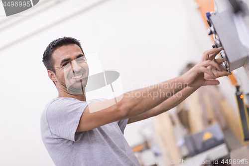 Image of worker in a factory of wooden furniture