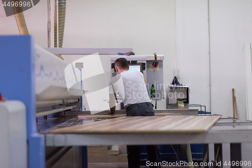 Image of worker in a factory of wooden furniture