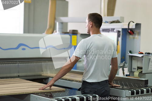 Image of worker in a factory of wooden furniture