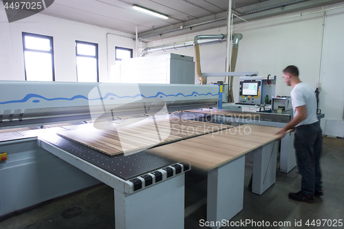 Image of worker in a factory of wooden furniture