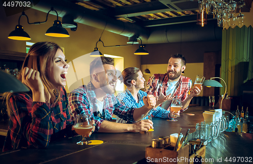 Image of Sport, people, leisure, friendship and entertainment concept - happy football fans or male friends drinking beer and celebrating victory at bar or pub